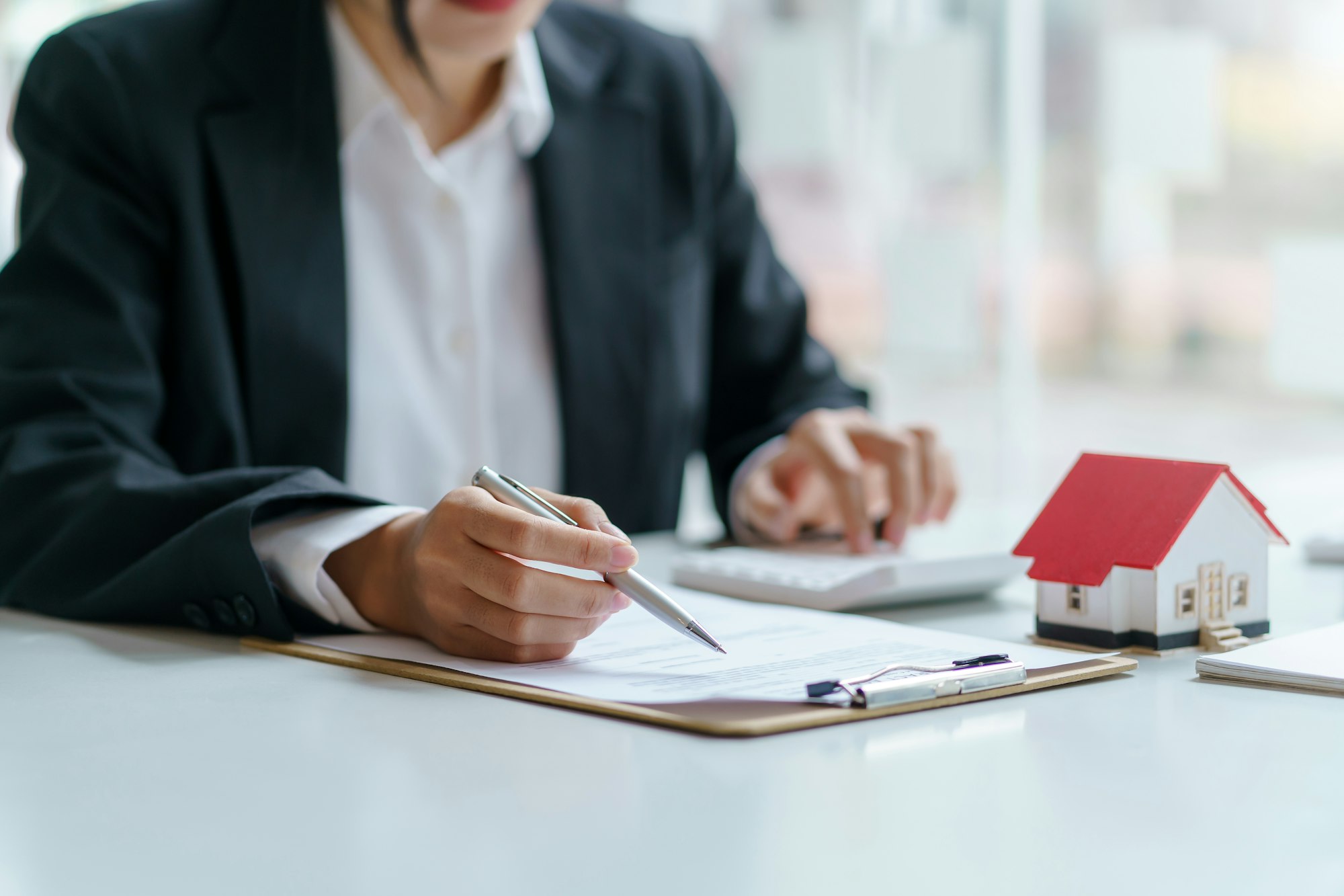 Signing a home loan purchase agreement with a real estate agent.